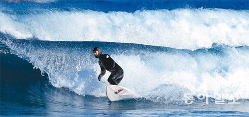 한여름을 상징하는 스포츠 중의 하나인 서핑을 겨울에 즐긴다. 영하 10도까지 기온이 떨어진 2일 강원 양양군 기사문해수욕장에서 한 서퍼가 겨울 파도 위를 질주하고 있다. 양양=신원건 기자 laputa@donga.com