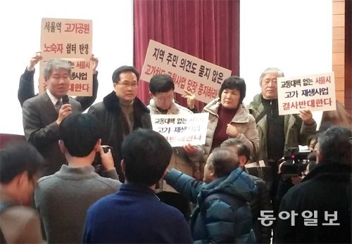 남대문시장 상인과 인근 지역 주민들이 12일 서울 중구 포스트타워 대회의실에서 열릴 예정이던 전문가 토론회 개최를 막으려 피켓을 들고 단상을 점거하고 있다. 이철호 기자 irontiger@donga.com