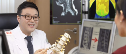 고도일 병원장이 뼈 모형을 들고 환자에게 디스크질환을 설명하고 있다. 고도일병원 제공