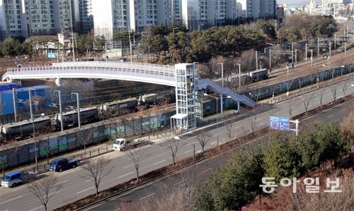 발걸음 뜸한 천천육교 경기 수원시 장안구 천천동에 놓인 천천육교를 지나는 행인들의 발걸음이 뜸하다. 이
 육교는 원래 사진 오른쪽 하단의 8차로 도로와 경부선 철로 위를 지나 사진 왼쪽 상단의 아파트 단지까지 연결될 예정이었지만 
주민들의 의견 차이에도 불구하고 건설을 밀어붙인 탁상행정 탓에 철길 위에만 놓인 반쪽짜리 육교가 됐다. 수원=최혁중 기자 
sajinman@donga.com