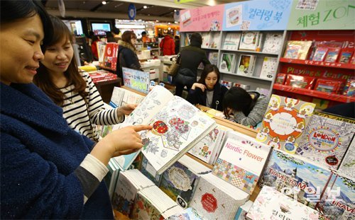 15일 오후 서울 종로구 교보문고 광화문점을 찾은 고객들이 서점에 마련된 색칠공부 코너를 찾아 책을 살펴보고 있다. 최근 서점에는 90여 종의 어른용 색칠공부 책이 나와 인기를 얻고 있다. 전영한 기자 scoopjyh@donga.com