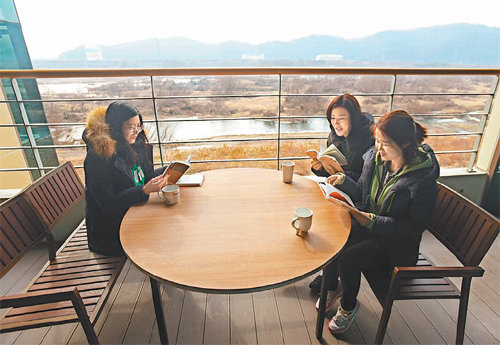 2일 대구 동구 안심도서관 옥상 쉼터에서 이용객들이 금호강 풍경과 커피를 즐기며 책을 읽고 있다. 대구 동구 제공