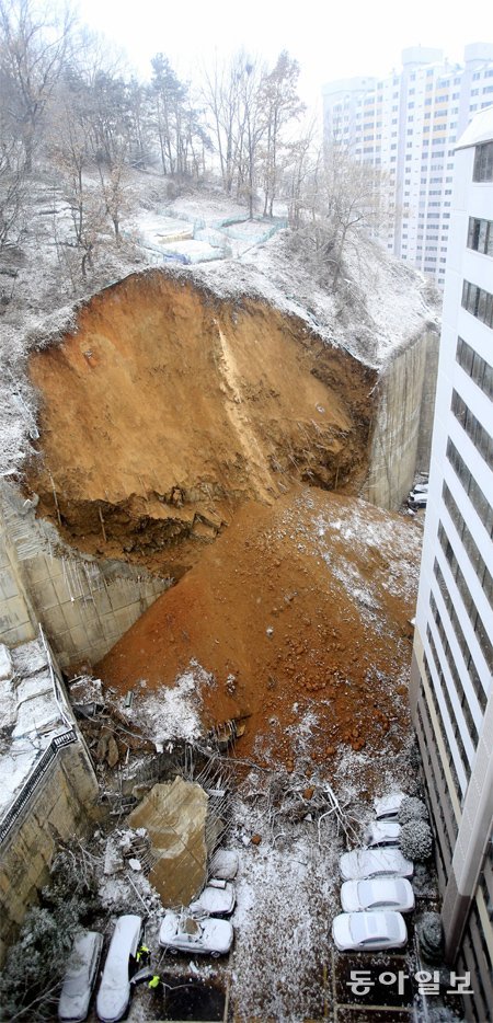 토사 쏟아져… 주민들 긴급 대피 5일 광주 남구 봉선로 대화아파트 뒤편 옹벽이 무너져 옹벽 아래 주차된 차량 40여 대가 흘러내린 콘크리트와 토사에 파묻혔다. 사고 직후 아파트 입주민 490여 명도 긴급 대피했다. 광주=박영철 기자 skyblue@donga.com