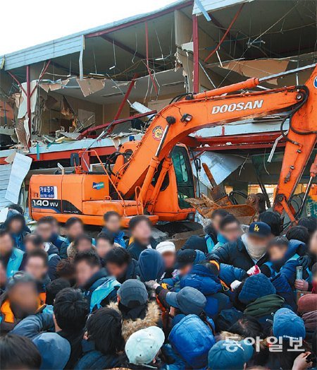 철거 2시간만에 중단 6일 오전 서울 강남구 구룡마을에서 주민회관을 철거하다 서울행정법원의 잠정 중단 
명령을 받고 철수하려던 중장비를 주민들이 가로막자 이에 맞선 강남구청 공무원과 용역업체 직원들이 뒤엉켜 몸싸움을 벌이고 있다. 
500여 명이 투입된 이번 철거작업은 2시간여 동안 이어졌다. 최혁중 기자 sajinman@donga.com
