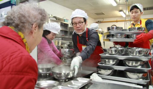 CJ오쇼핑 변동식 대표이사가 방배노인종합복지관 구내식당에서 복지관을 찾은 노인들에게 떡국을 배식하고 있다.