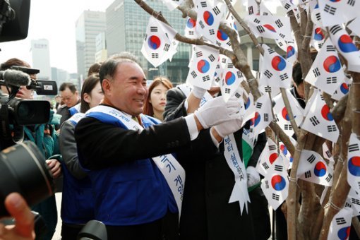 바르게살기운동중앙협의회 윤홍근 회장이 태극기 달기 캠페인에 참여하고 있다.