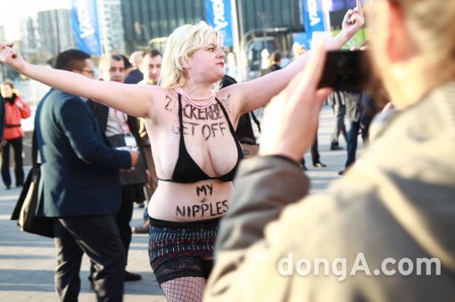 국제 여성인권단체(FEMEN) 소속 한 여성 회원이 2일 MWC가 열리고 있는 스페인 바르셀로나 피아 그란비아 전시장 앞에서 누드 시위를 벌이고 있다.
