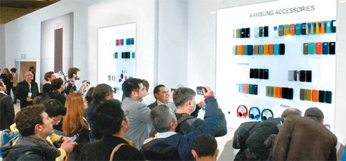 이달 1일(현지 시간) 스페인 바르셀로나 컨벤션센터에서 열린 ‘갤럭시S6’ 언팩 행사 전시장에서 관람객들이 이날 함께 공개된 스마트폰 케이스 등 액세서리를 구경하고 있다. 삼성전자 제공