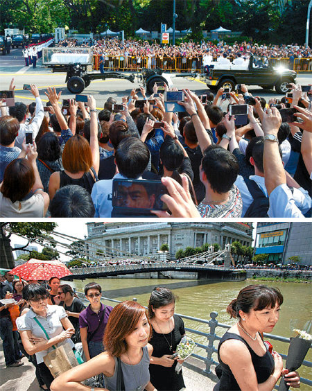 스마트폰 촬영… 줄이은 조문행렬 25일 오전 리콴유 전 싱가포르 총리의 영구를 실은 운구차가 
대통령궁에서 나와 국민 조문이 이뤄질 국회의사당 쪽으로 향하자 궁 밖에 몰려 있던 시민 수천 명이 일제히 스마트폰을 들어 사진을 
찍고 있다(위 사진). 리 전 총리의 영구가 안치된 의사당 앞에 길게 줄을 서 조문 순서를 기다리고 있는 사람들(아래 사진). 
싱가포르=AP 뉴시스 로이터 뉴스1
