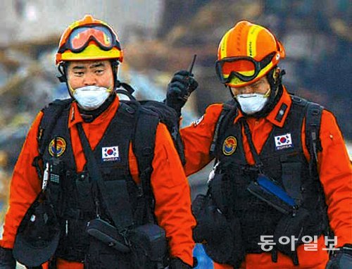 2011년 3월 일본 지진 피해 현장에서 한국 119구조대원들이 태극기가 부착된 조끼를 입고 현장을 수색하고 있다. 행정자치부는 국내에서 근무하는 경찰과 소방공무원 제복에도 태극기를 다는 방안을 검토하고 있다. 동아일보DB