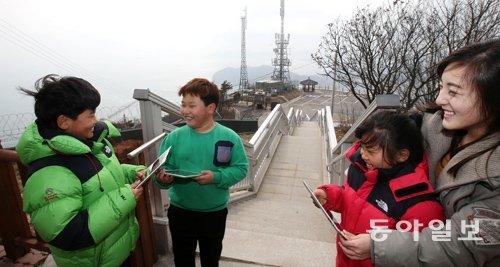 백령초등학교 학생들이 KT IT서포터즈와 함께 태블릿 PC로 야외에서 스마트 수업을 하고 있다.