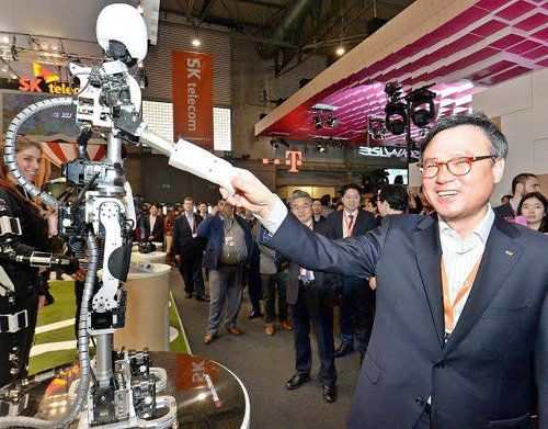 장동현 SK텔레콤 사장이 3월 스페인 바르셀로나에서 개최된 ‘모바일월드콩그레스(MWC) 2015’에서 5세대(5G) 기술로 제작된 로봇과 악수하고 있다. SK텔레콤 제공