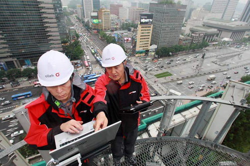 KT 직원들이 서울 종로구 광화문 인근 건물의 옥상에 위치한 무선통신용 기지국 설비를 점검하고 있다. KT는 광랜보다 최대 10배 빠른 인프라를 기반으로 ‘기가토피아’라는 새로운 패러다임을 열고 있다. KT 제공