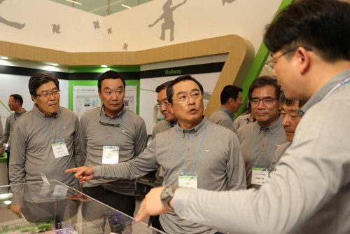 구자열 LS그룹 회장(가운데)이 지난해 9월 경기 안양 LS타워에서 열린 ‘2014 T-Fair’에 참가해 연구원에게 질문을 하고 있다. LS그룹 제공