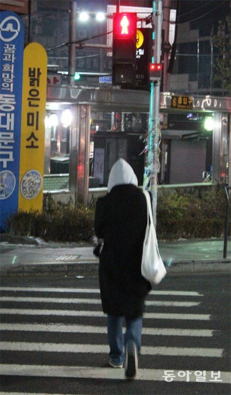 횡단보도 신호등의 빨간불을 아랑곳하지 않고 한 여성이 도로를 건너고 있다. 동아일보DB