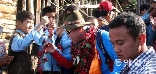 5일 네팔 고르카 주 만드레 마을에서 열린 엄홍길휴먼재단의 제13차 학교 기공식에서 이 학교 학생이 엄홍길 대장에게 꽃다발을 걸어주고 있다. 고르카=황성호 기자 hsh0330@donga.com