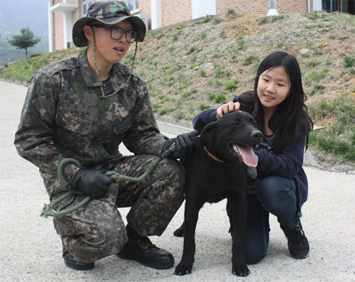 22일 육군 제1야전군사령부 군견교육대에서 진예나 양(12·오른쪽)이 분양받은 퇴역 군견을 쓰다듬고 있다. 춘천=이인모 기자 imlee@donga.com