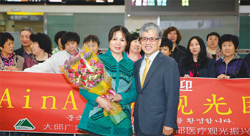 25일 대구공항에서 열린 중국인 의료관광객 환영식에서 김연창 대구 경제부시장(오른쪽)이 베이징에서 온 관광객 대표에게 꽃다발을 주고 있다. 대구시 제공