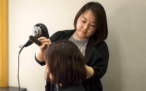 방송 분장 회사에서 시간선택제 근로자로 일하는 양서린 씨가 29일 서울의 한 방송국에서 출연자의 머리를 손질하고 있다. 고용노동부 제공