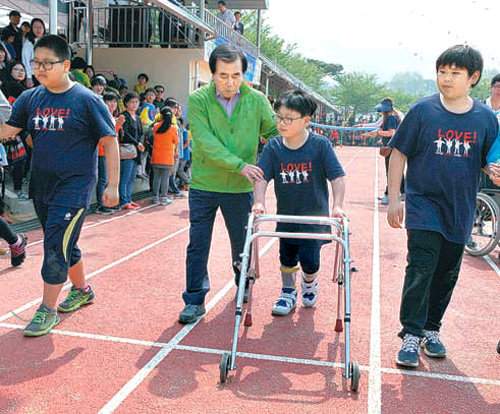 충남 보령시 명천초등학교 6학년 송명관 군(오른쪽에서 두번째)이 1일 열린 운동회에서 김지철 도교육감(오른쪽에서 세번째)의 도움을 받아 100m 달리기 결승점을 향해 달리고 있다. 충남교육청 제공