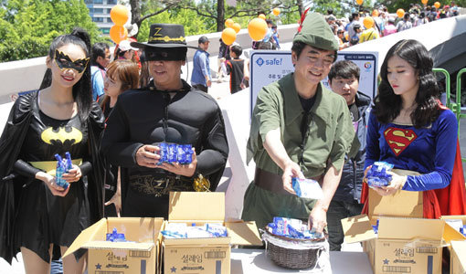 롯데 자이언츠 이창원 사장(오른쪽에서 2번째)과 이윤원 단장(왼쪽에서 2번째)이 어린이날인 5일 사직구장 앞에서 각각 ‘피터팬’과 ‘쾌거 조로’로 분장한 뒤 어린이 팬들에게 선물을 전하고 있다. 사진제공｜롯데 자이언츠