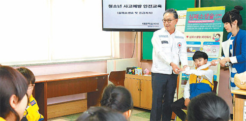 황규철 인천적십자사 회장이 지난달 27일 인천 연수구 선학초등학교에서 여성 강사와 함께 학생들에게 부목 사용법을 설명하고 있다. 인천적십자사는 올해 초중고교의 신청을 받아 청소년 사고 예방 안전교육을 진행하고 있다. 인천적십자사 제공