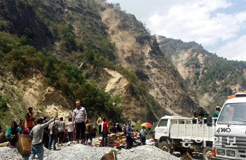 12일 오후 네팔 고르카 주 만드레마을 주민들이 엄홍길휴먼재단의 구호물품을 받기 위해 기다리던 도중 지진이 발생해 산사태가 
일어나자 황급히 공터로 몸을 피하고 있다. 절벽에는 산사태로 발생한 뿌연 흙먼지가 선명하다. 고르카=박성진 기자 
psjin@donga.com