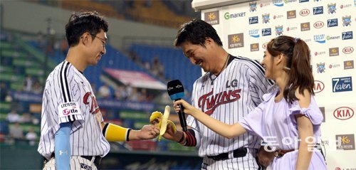 LG 정성훈(왼쪽)이 2013년 7월 9일 롯데전에서 끝내기 안타를 치고 수훈선수 인터뷰를 하던 이진영에게 축하의 바나나를 건네고 있다. 동아일보DB