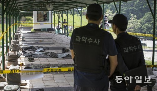 곳곳에 혈흔… 널브러진 전투화 육군 헌병과학수사대 수사관들이 14일 서울 서초구 내곡동 예비군 훈련소 내 사격장을 살펴보고 있다. 육군 중앙수사단이 이날 공개한 전날 사고 현장에는 혈흔이 곳곳에 보였고, 피해자들의 전투화가 널려 있었다. 박영대 기자 sannae@donga.com