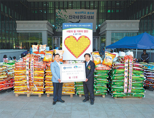 구본영 충남 천안시장(왼쪽)이 16일 백석대에서 열린 전국태권도대회를 마친 뒤 학교 측이 모은 쌀 607포대를 전달받고 있다. 백석대 제공