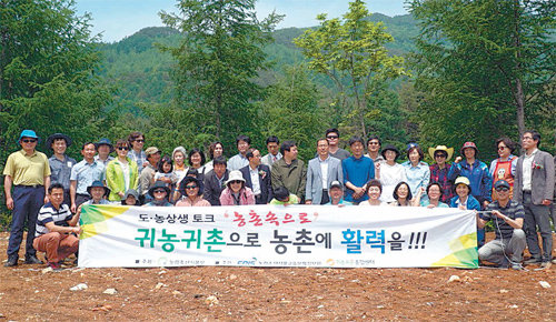 강원 평창군 방림면 방림리 꽃숲마을로 이주할 서울 성미산마을 주민들이 17일 현지에서 기공식을 가진 뒤 기념 촬영하고 있다. 귀농귀촌종합센터 제공