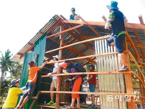 림 브에스나씨의 무료 치료를 주선한 대전 하기동성당 신부들이 올 초 캄보디아 현지에서 집짓기 봉사활동을 벌이고 있다. 시아누크빌=이기진 기자 doyoce@donga.com