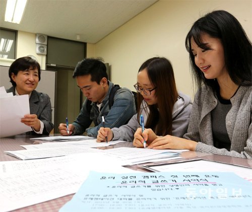 19일 서울 종로구 상명대에서 학생 세 명이 올바른 글쓰기를 다짐하는 서약서에 서명하고 있다.  홍진환 기자 jean@donga.com
