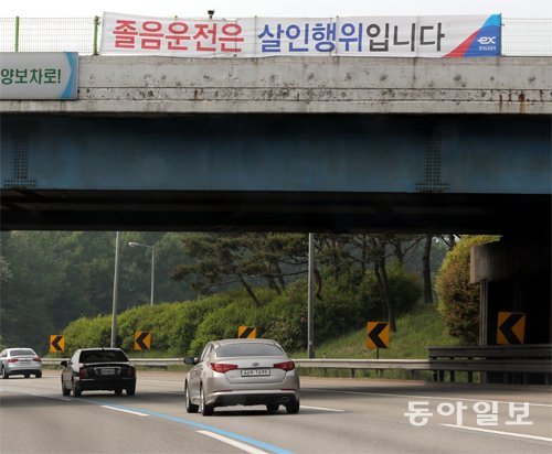 19일 충남 천안시 경부고속도로(하행선)의 한 횡단육교 위에 ‘졸음운전은 살인행위입니다’라는 졸음운전 경고 문구가 적힌 현수막이 걸려 있다. 천안=김경제 기자 kjk5873@donga.com