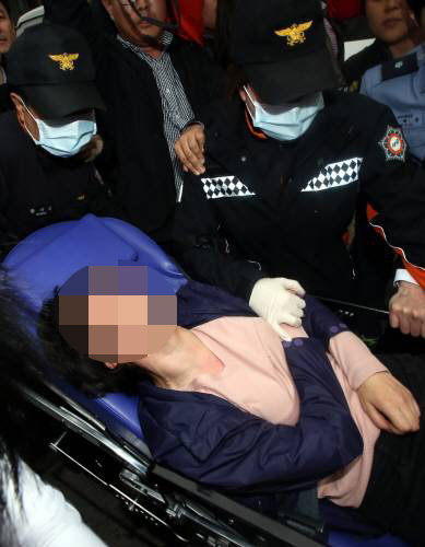 2014년년 4월 11일, 대구지방법원에서 숨진 어린이의 고모가 공판도중 실신해 구급차에 실려나가고 있다.