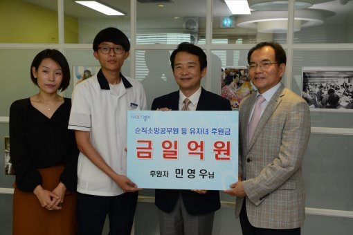 민영우 씨(오른쪽)가 순직 소방공무원 유자녀 후원금으로 1억 원을 경기도에 쾌척했다.
