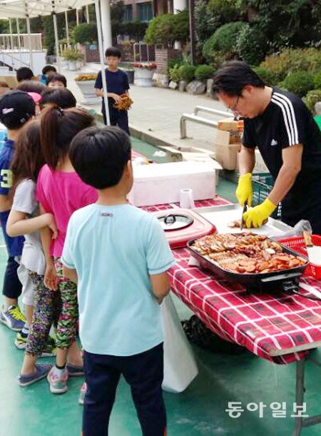 지난달 30일 ‘캠핑데이’가 열린 서울 광진구 광장동 광남초등학교 운동장에서 뛰어놀던 아이들이 아버지회가 마련한 음식을 먹기 위해 줄을 서서 기다리고 있다. 김재형 기자 monami@donga.com