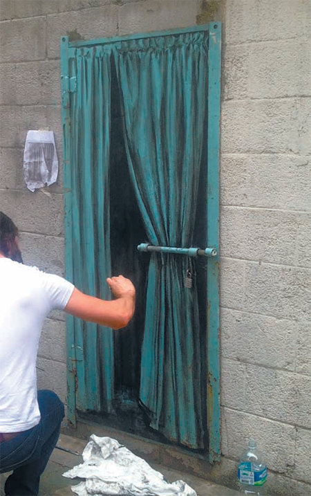 페자크가 서울 YMCA 별관 골목 철문에 커튼을 그리는 모습. 페자크 제공