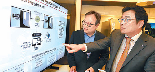 LG유플러스 김선태 SD(Service Development)본부장(오른쪽)이 서울디자인재단 이근 대표이사(왼쪽)에게 서울 중구 을지로 동대문디자인플라자에 적용할 비콘 기술 개념을 설명하고 있다. LG유플러스 제공