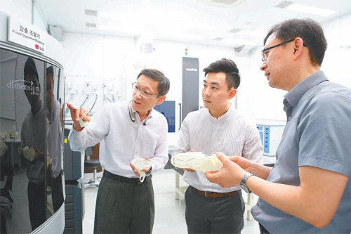 생활용 방습제 제품을 만드는 벤처기업 데시존의 김윤수 대표(가운데)가 정호근 LG전자 수석연구원(왼쪽), 서석원 수석연구원과 함께 3D 프린터로 시제품을 제작하는 과정을 지켜보고 있다. LG그룹 제공