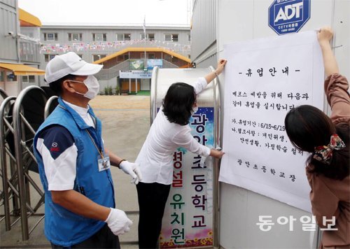 15일 부산 수영구 광안초등학교 정문에 학교 관계자들이 휴업 실시를 알리는 안내문을 붙이고 있다. 부산에서 두 번째 메르스 
확진환자가 발생하면서 이 지역의 유치원과 초등학교, 중학교 등 45곳이 휴업에 들어갔다. 부산=서영수 기자 
kuki@donga.com