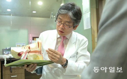 김성근 이비인후과 원장이 환자에게 귀 모형을 보면서 난청의 원인에 대해 설명하고 있다. 동아일보DB