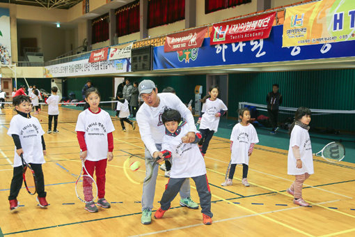 테니스는 심혈관 질환의 개선과 비만 치료 및 예방 등 신체적 건강 증진에 큰 도움을 줄 수 있는 유용한 스포츠다. 한국을 대표하는 테니스 스타 출신인 이형택이 ‘테니스 행복충전 행사’에서 어린이들에게 기본기를 가르치고 있다.
