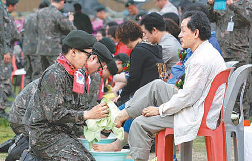 6포병여단 병사들이 지난달 본부 연병장에서 열린 부모님 초청 세족식 행사에서 부모님의 발을 씻겨 드리고 있다. 6포병여단 제공