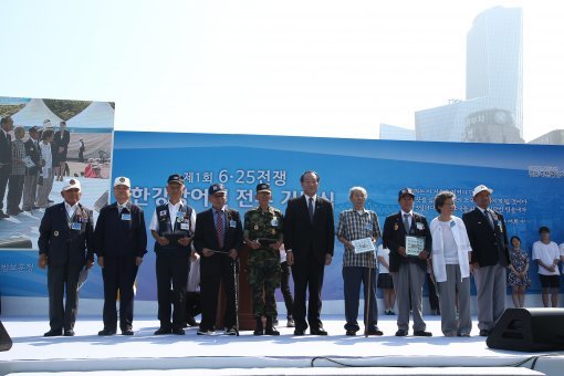 박승춘 보훈처장(가운데)이 28일 서울 영등포구 여의도 광장 문화의 마당에서 열린 6·25전쟁 한강방어선 전투 첫 정부 기념식에 참석해 참전용사 및 전사자 유족들과 기념촬영을 하고 있다. 보훈처 제공
