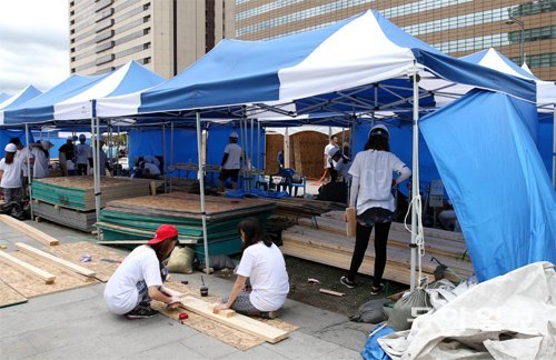 대학생 자원봉사자들이 서울 광화문광장의 세월호 천막촌을 추모공간으로 재정비하는 공사를 하며 각목을 정리하고 있다. 변영욱 기자 cut@donga.com