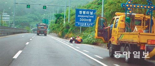 부산지방국토관리청 진영국토관리사무소 직원들이 8일 국도 25호선 정병터널 입구에서 도로 정비작업을 하고 있다. 강정훈 기자 manman@donga.com