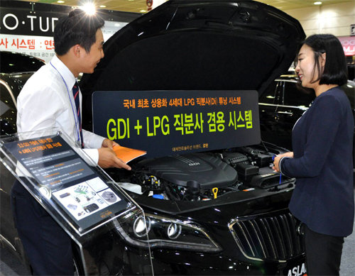 대체 연료 솔루션 기업 ‘로’는 아슬란 차량에 기존 가솔린 엔진에 액화석유가스(LPG)를 사용하도록 한 ‘LPG 직분사 시스템’을 설치해 전시했다. 한 관람객이 직원에게 설명을 듣고 있다. 서울오토살롱사무국 제공