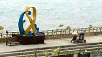 13일 전남 진도군 팽목항을 찾은 시민들이 우산을 쓰고 노란 리본을 형상화한 조형물을 바라보고 있다. 동아일보 독자 제공