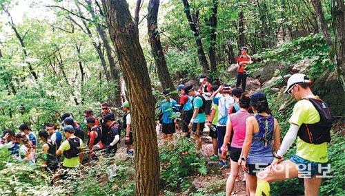11일 오전 서울 관악산에서 열린 한 스포츠용품 회사의 트레일러닝 행사에 참여한 참가자들이 좁은 등산로를 뛰어 내려가기 위해 등산객들이 지나가기를 기다리고 있다. 박성진 기자 psjin@donga.com